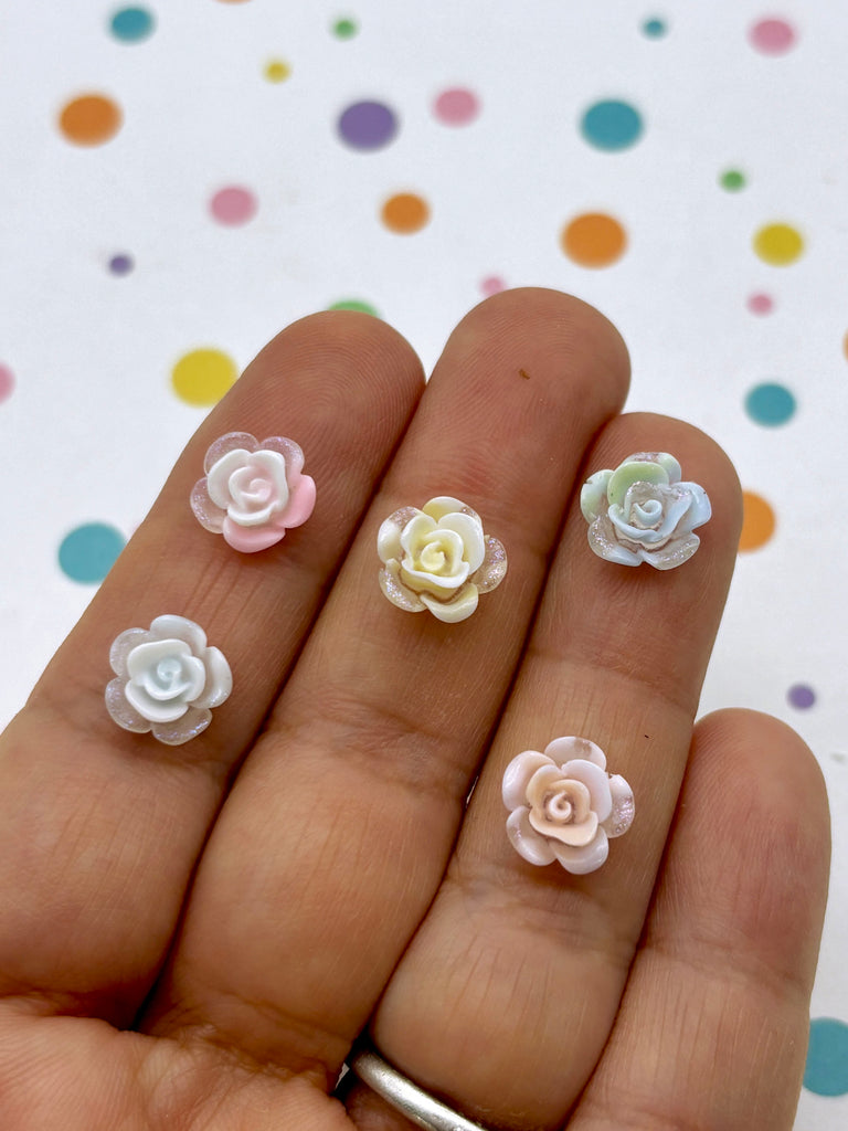 a person's hand with three small flowers on it