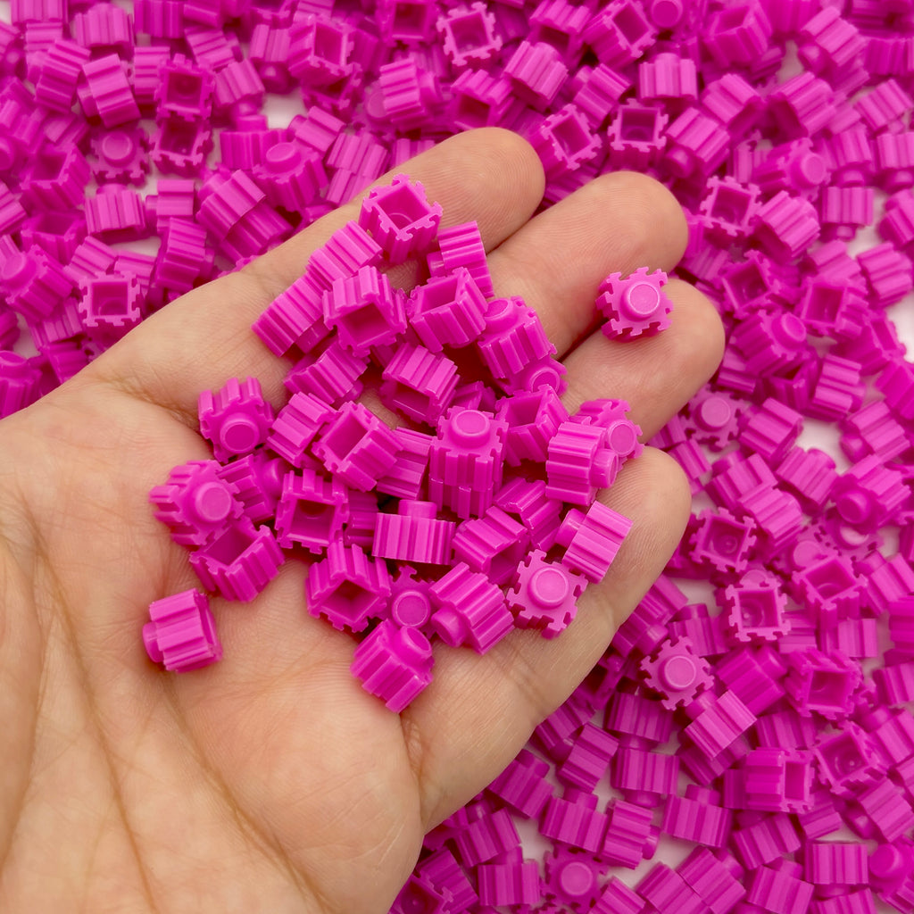 a hand holding a pile of pink legos