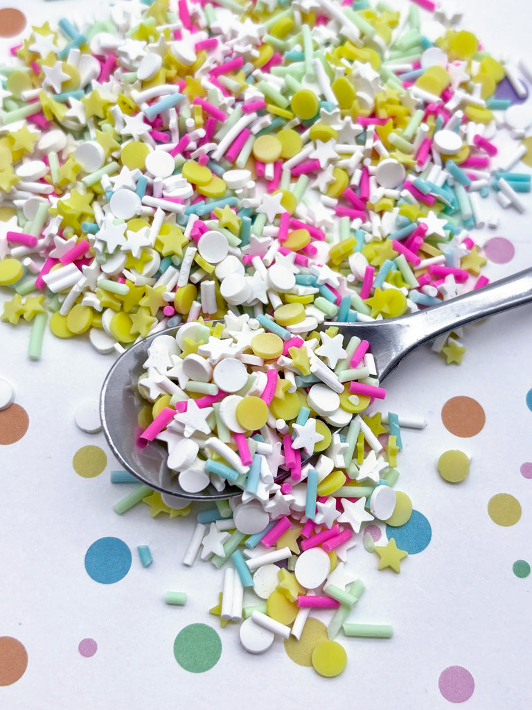 a spoon full of confetti sprinkles on a table