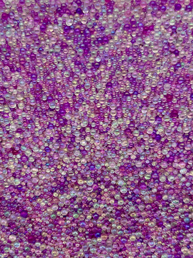 The image is a collage of various colored beads, including purple, pink, and white beads, arranged in a visually appealing manner.