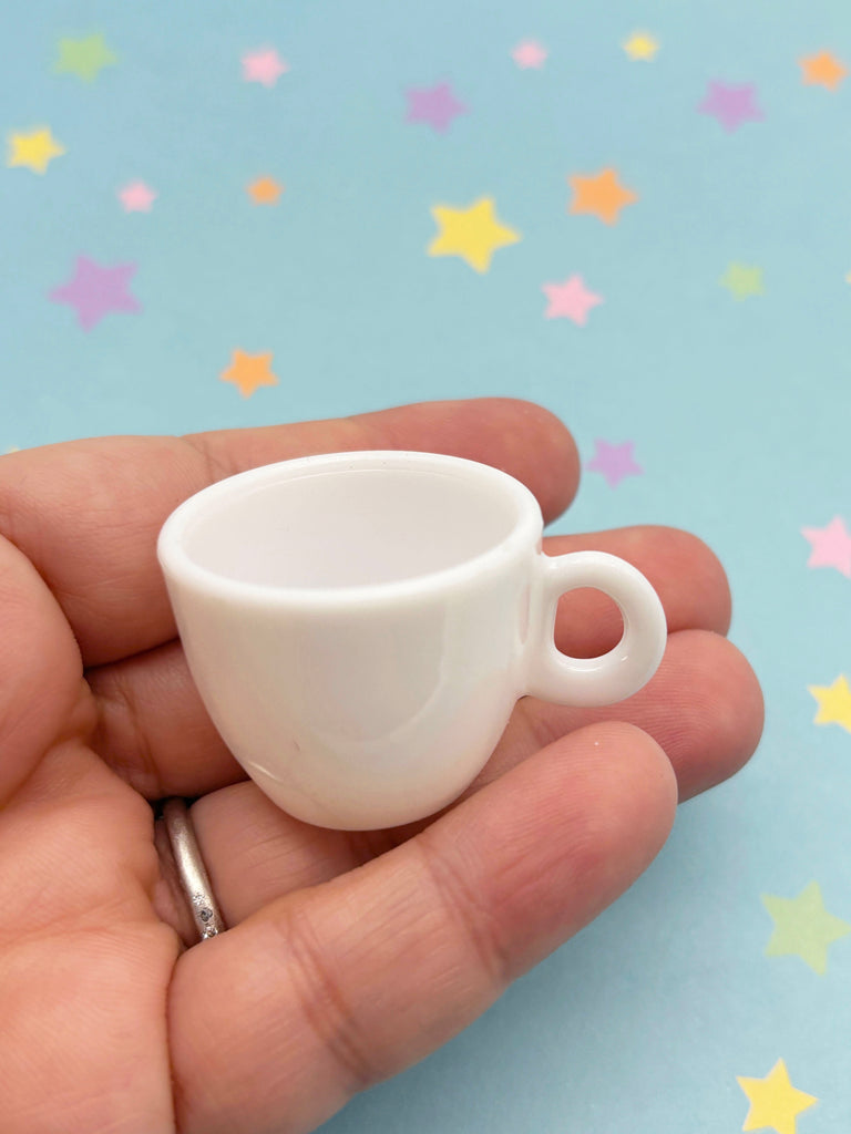 a miniature coffee cup in a persons hand