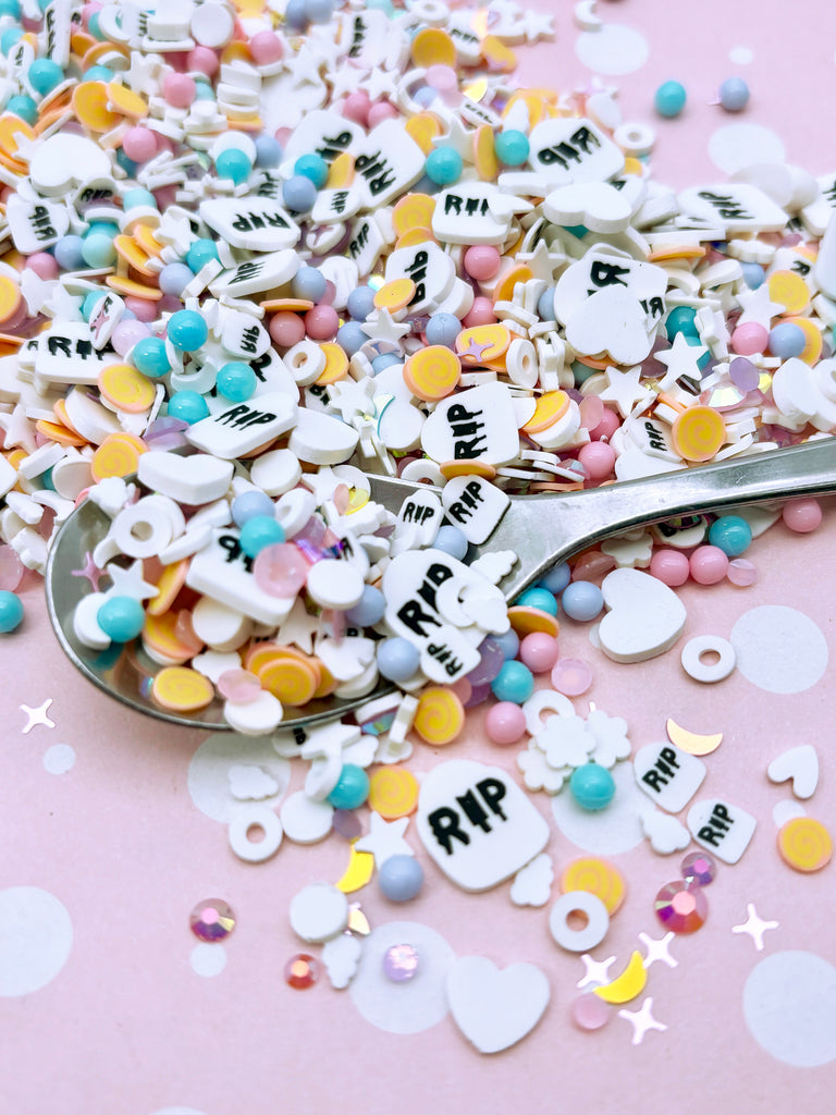 a spoon full of confetti on a pink table