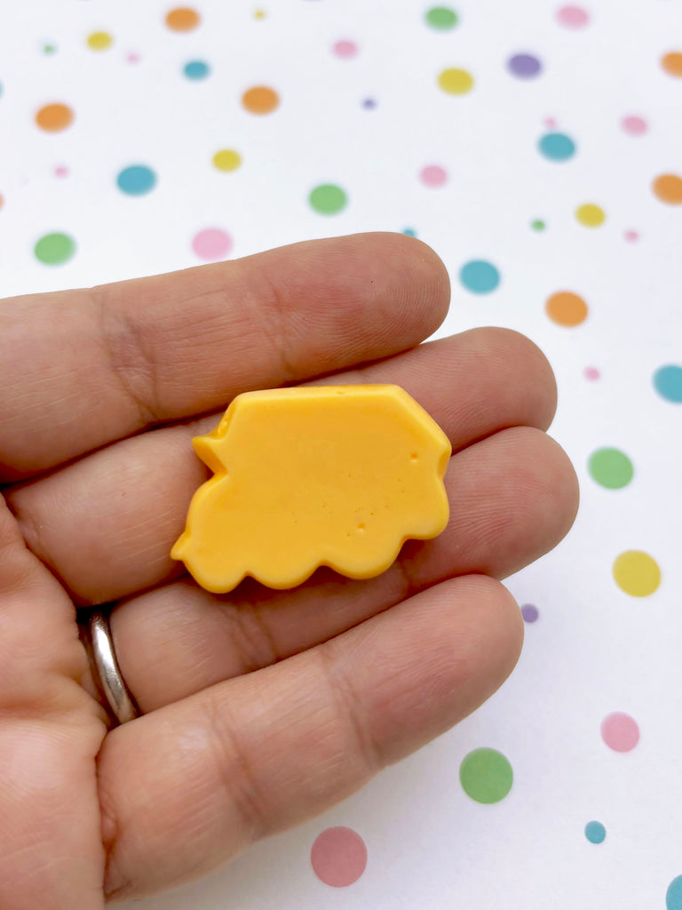 a person holding a small yellow object in their hand