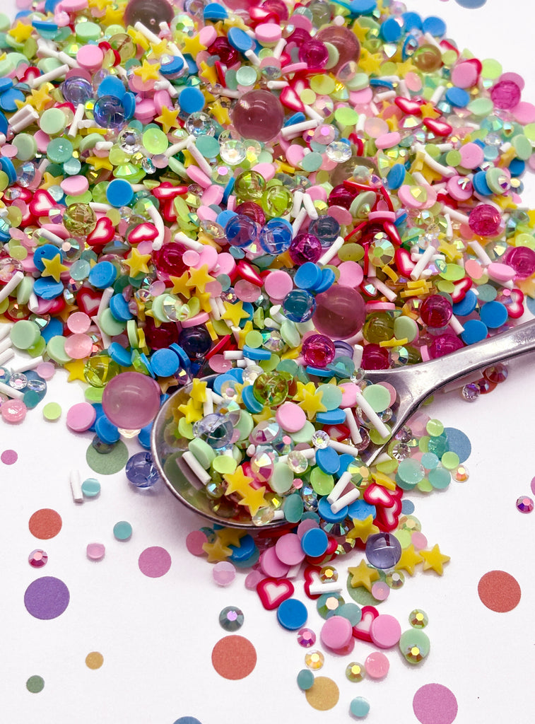 a spoon full of colorful confetti on top of a table