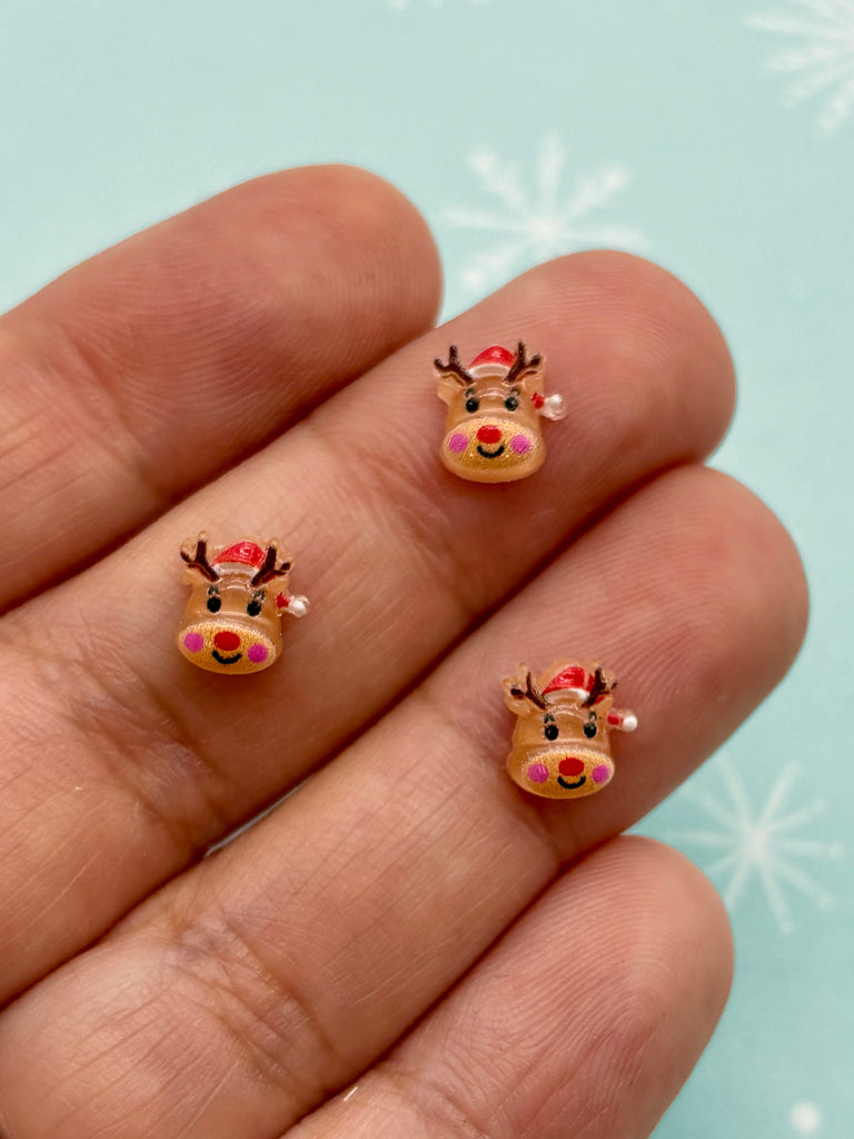 a hand holding a small pair of reindeer stickers