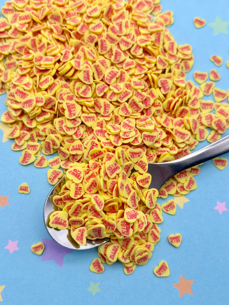 a spoon filled with yellow and red hearts