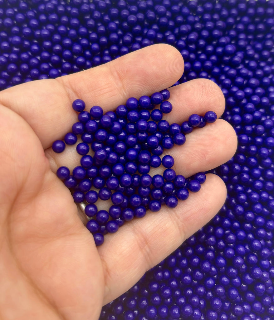 a hand holding a bunch of blue beads