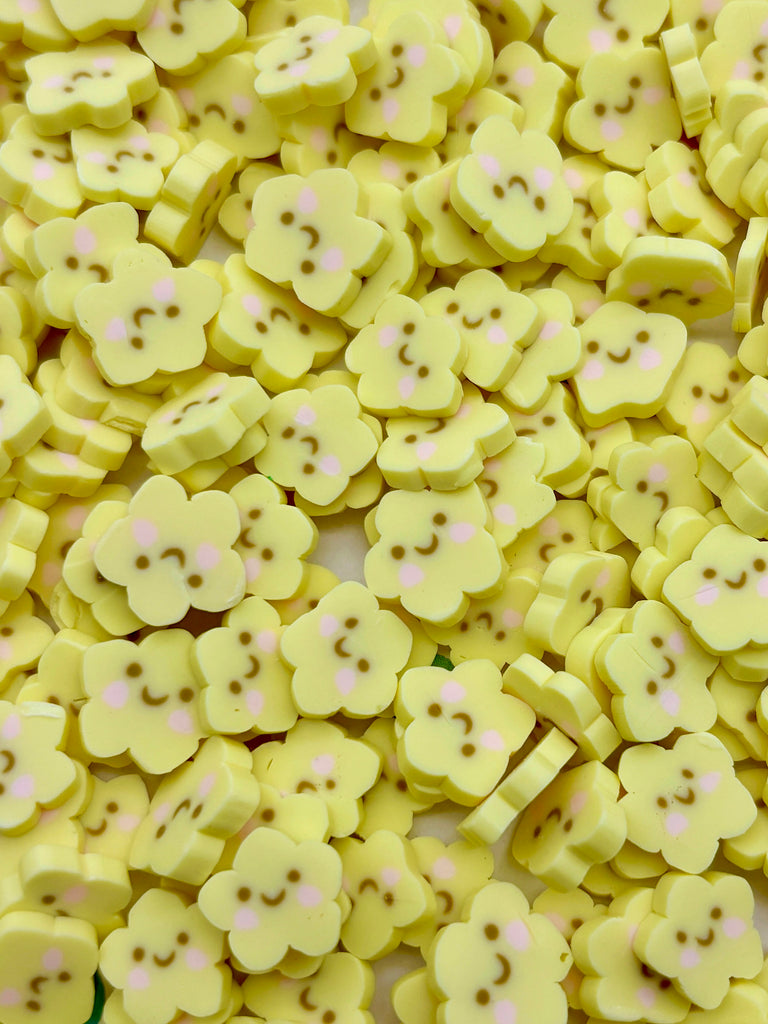 a pile of yellow buttons with pink dots