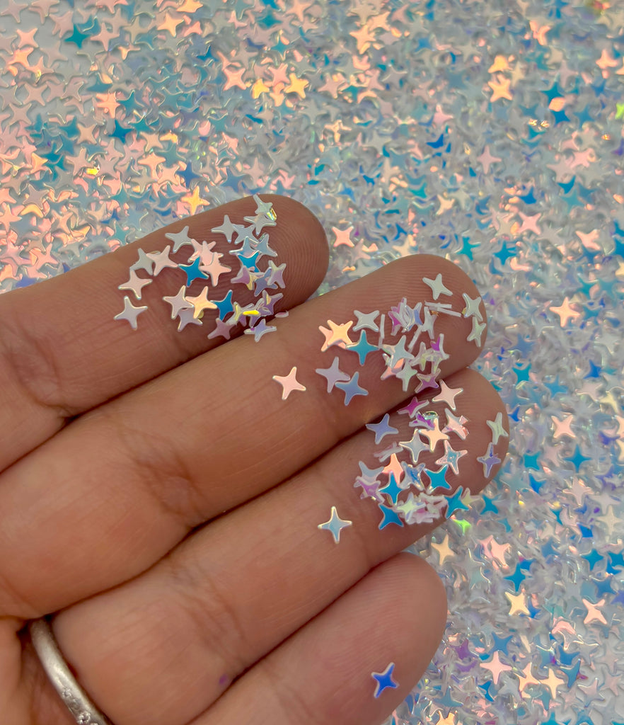 a hand holding a manicure with stars on it