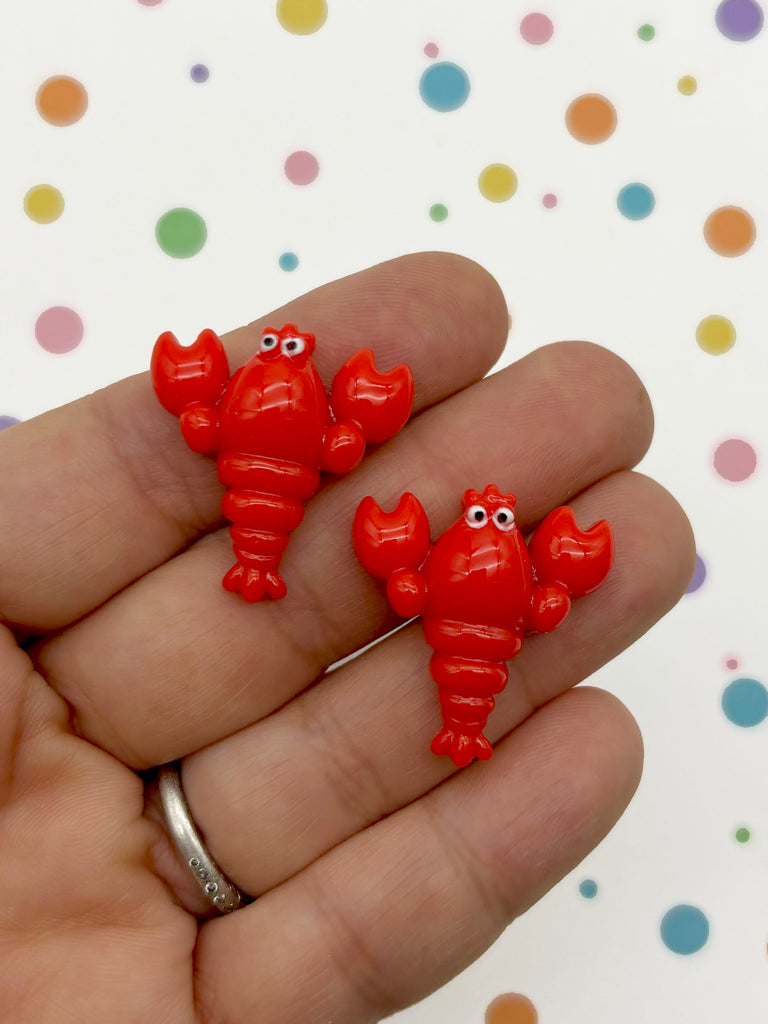 a person is holding three small red elephants