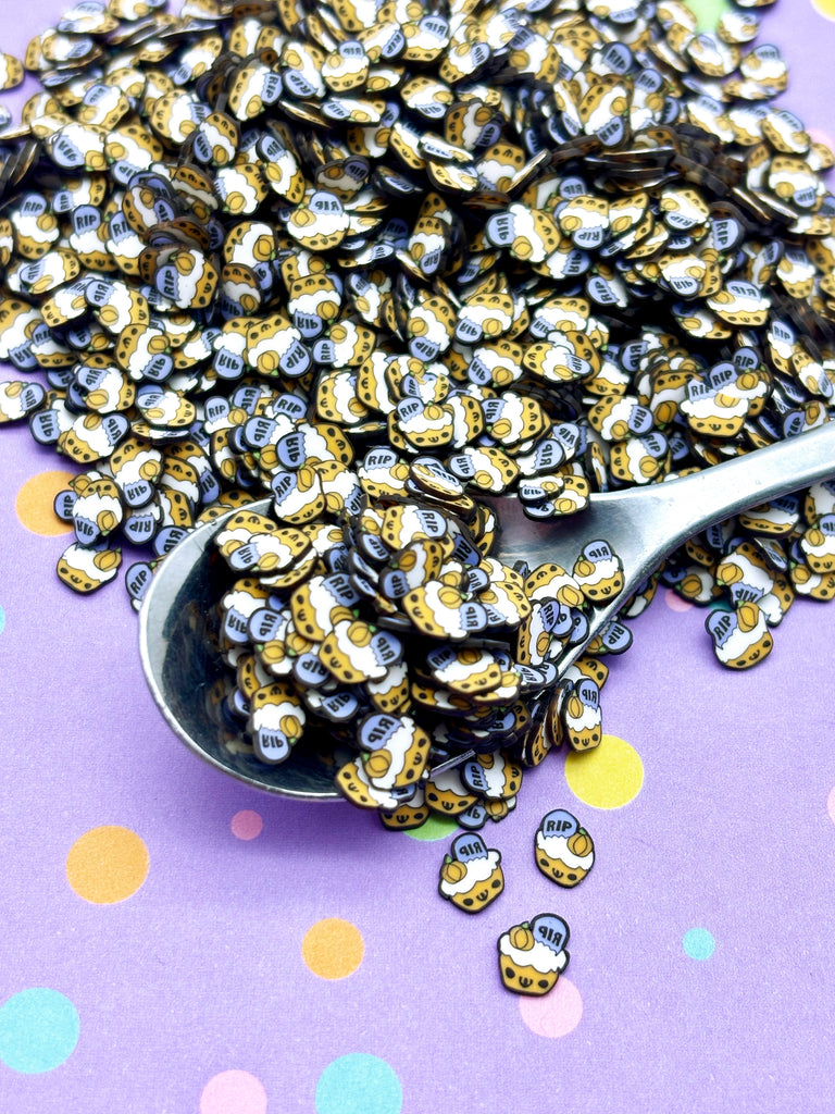 a spoon filled with lots of gold and black beads