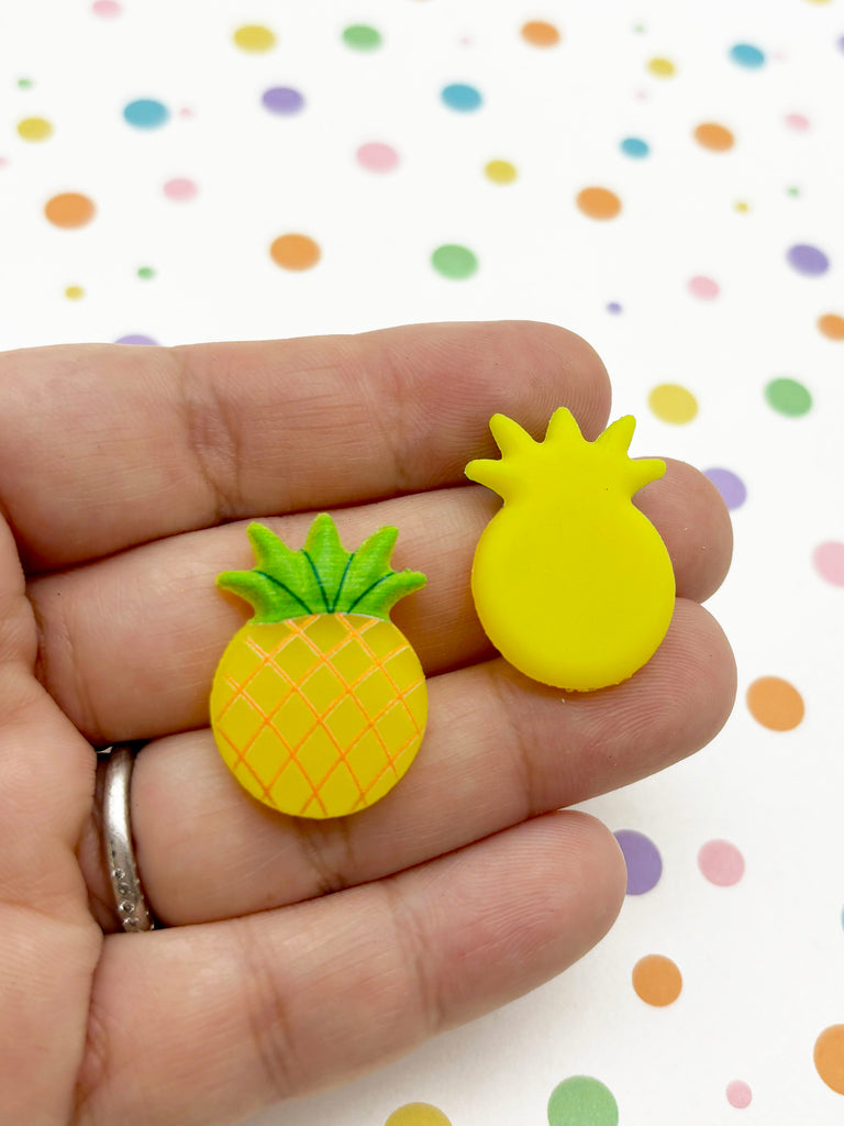a person holding a small yellow and green pineapple brooch