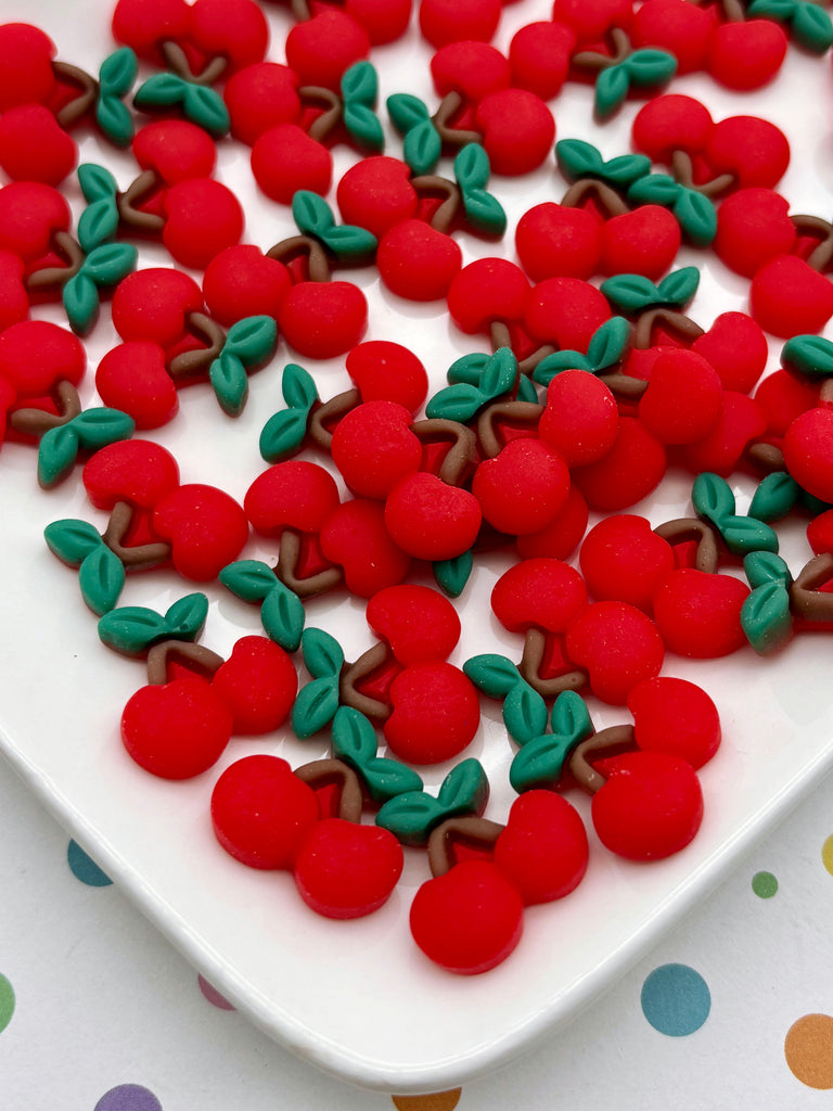 a white plate filled with red and green cherries, arranged in a visually appealing manner.