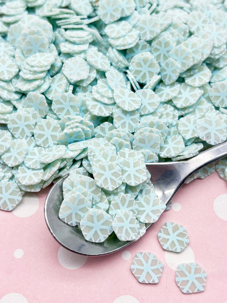 a spoon full of snowflakes sitting on top of a table