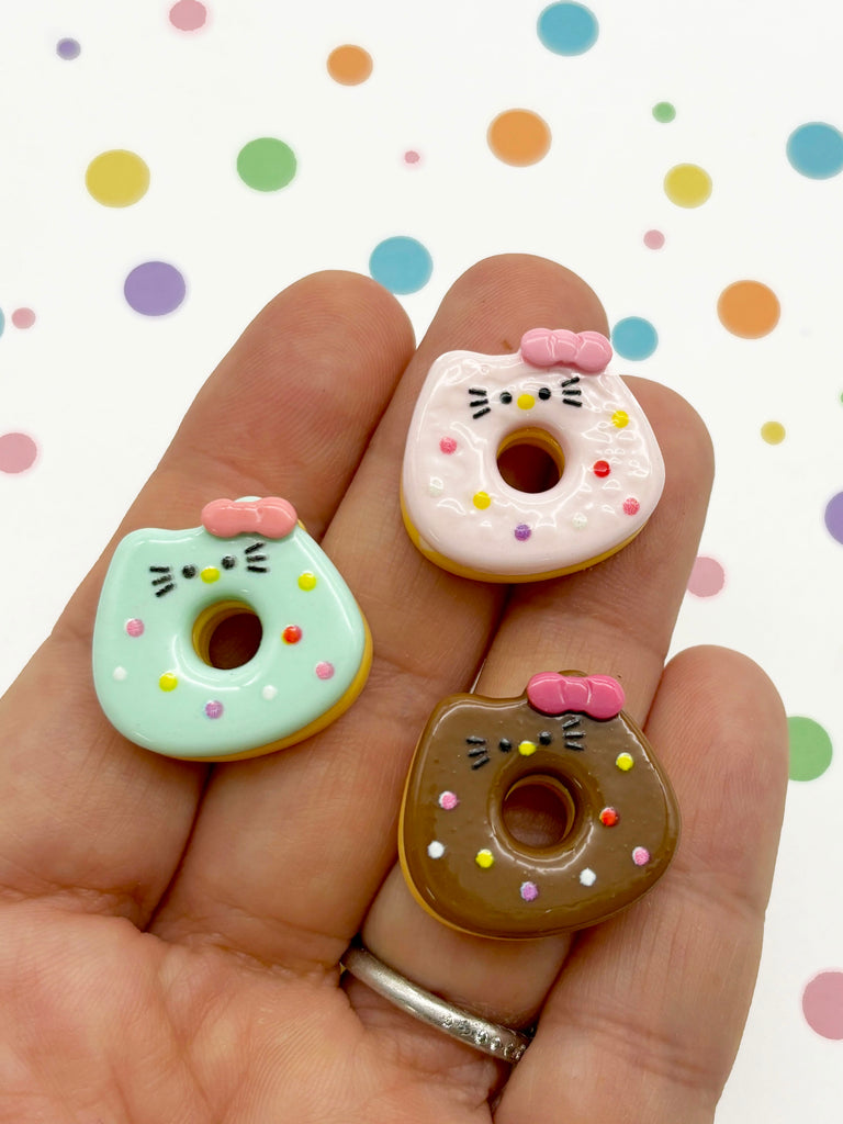 a person is holding three miniature donuts in their hand