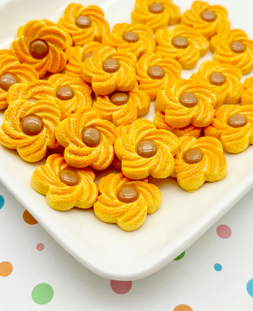 a white plate topped with lots of yellow cookies