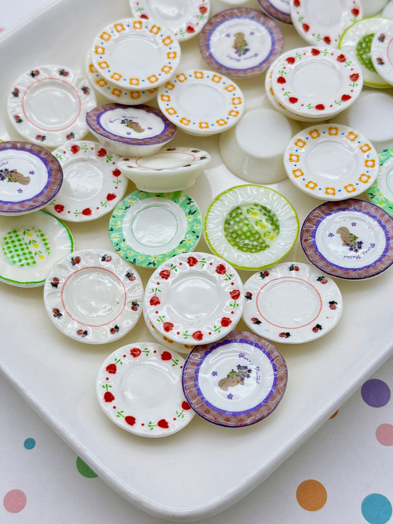 a collection of colorful, patterned plates and bowls arranged on a white surface.