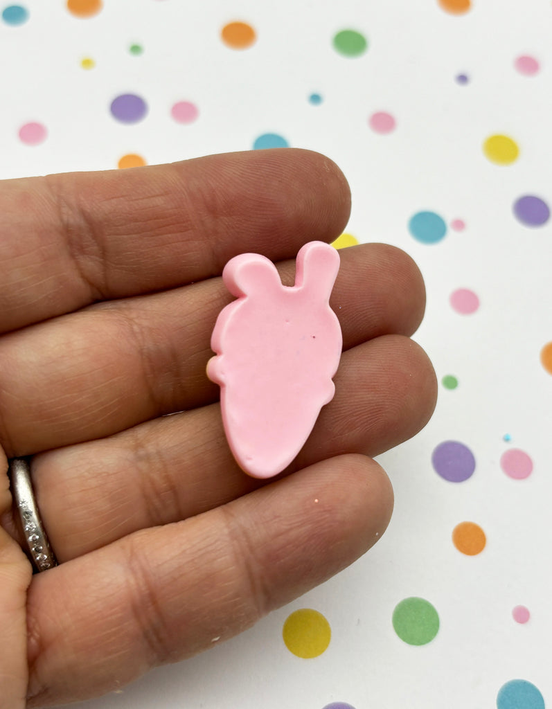 a person holding a pink bunny shaped object in their hand
