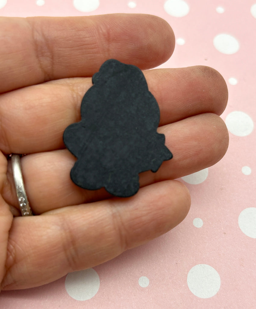 a person is holding a small black piece of wood