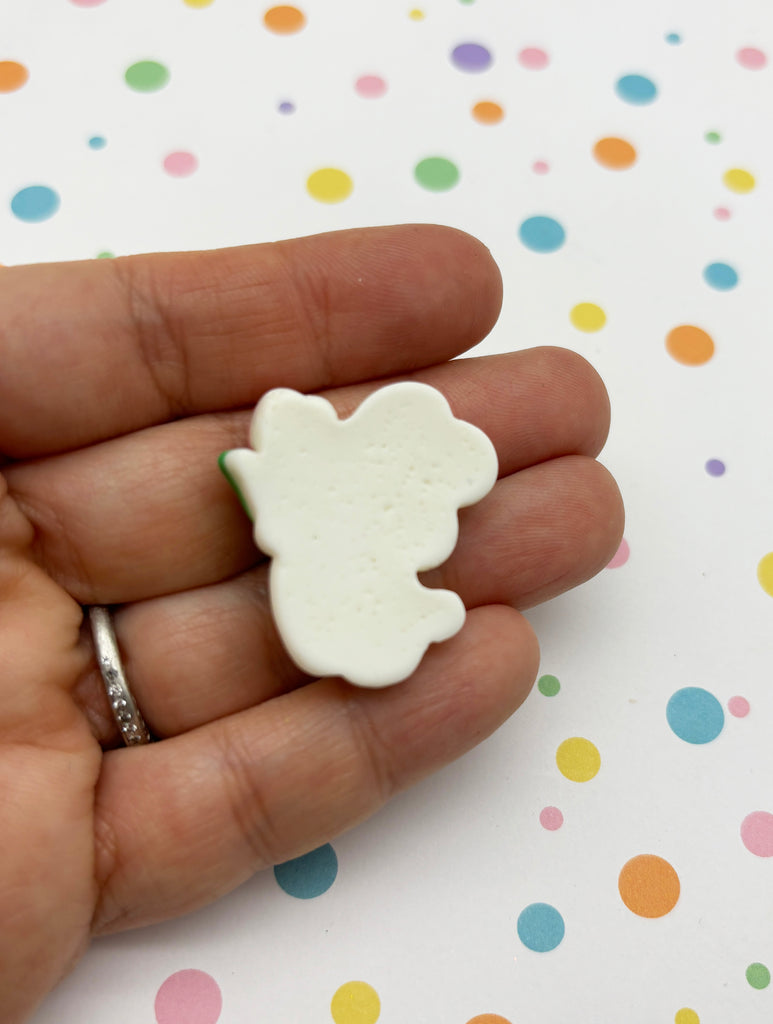 a hand holding a small white bear shaped ring
