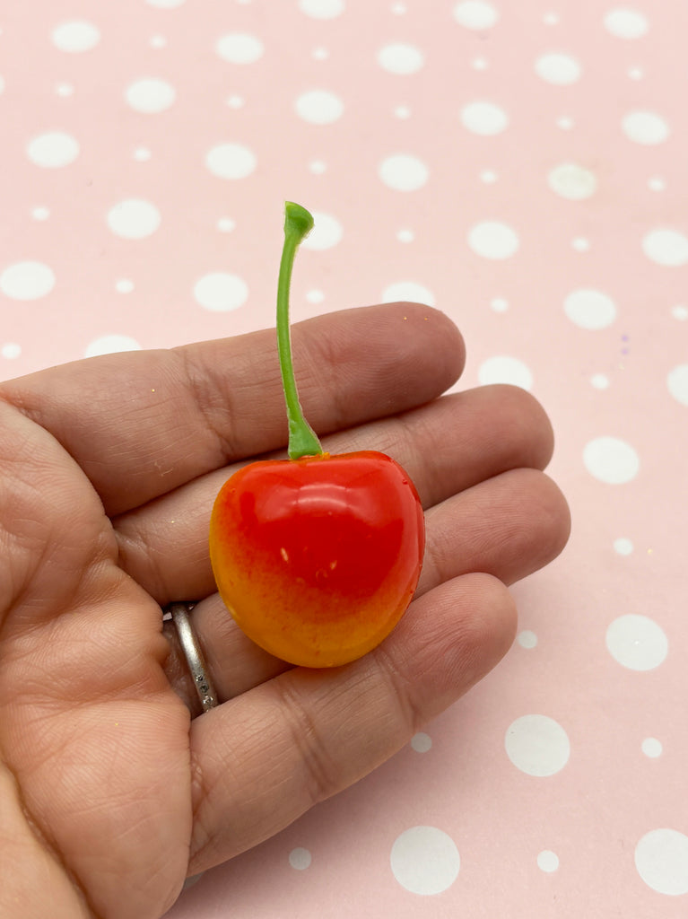a tiny cherry tomato being held in a hand