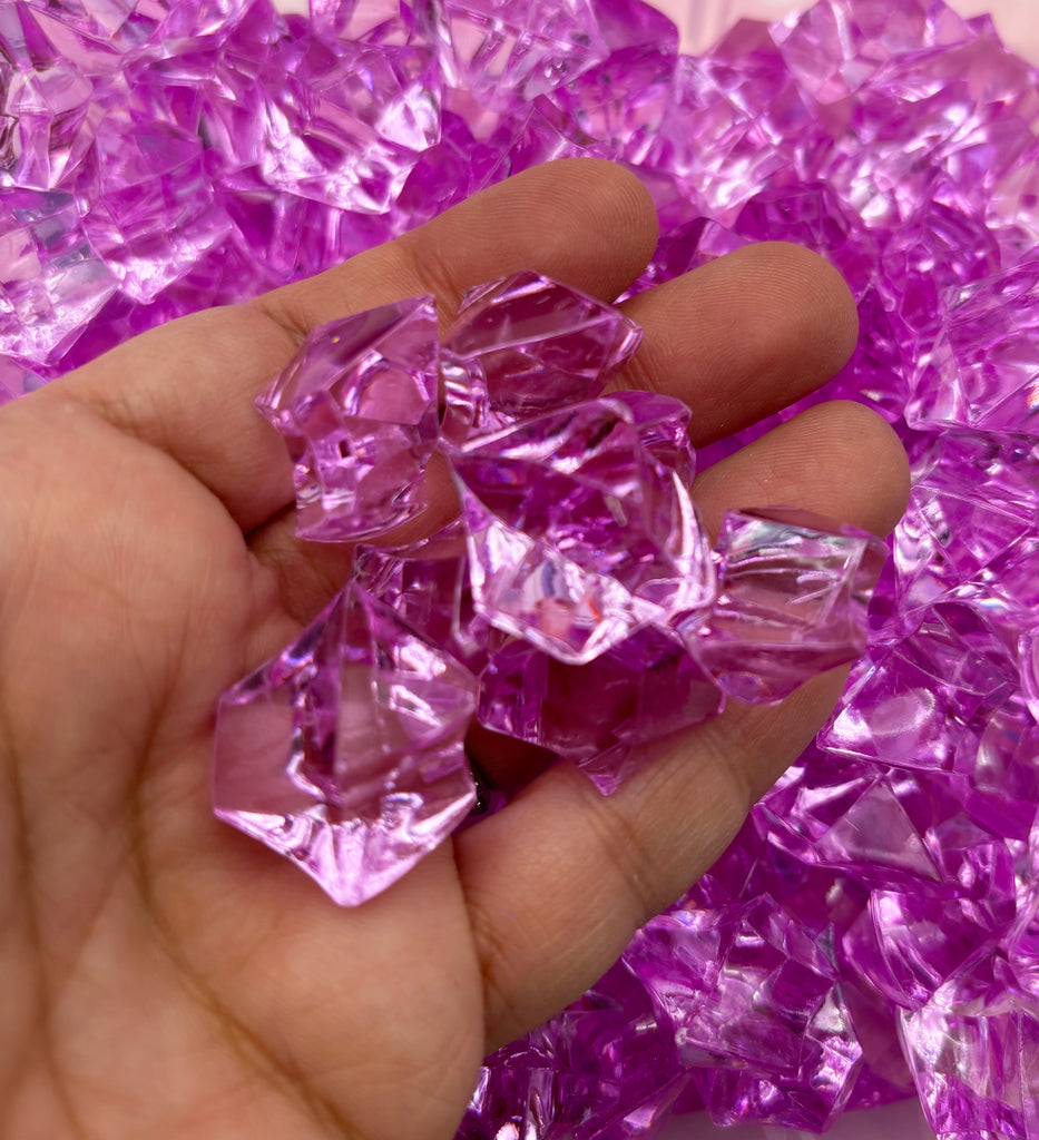 a hand holding a bunch of pink crystals