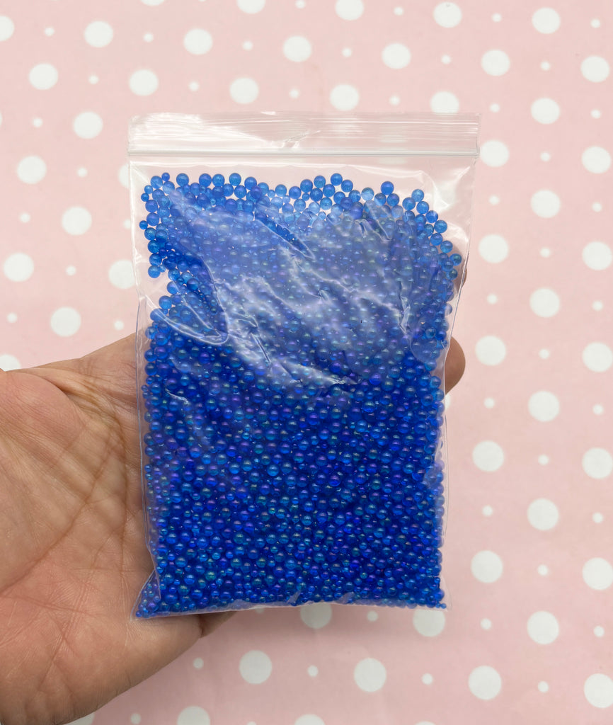 a hand holding a bag of blue beads