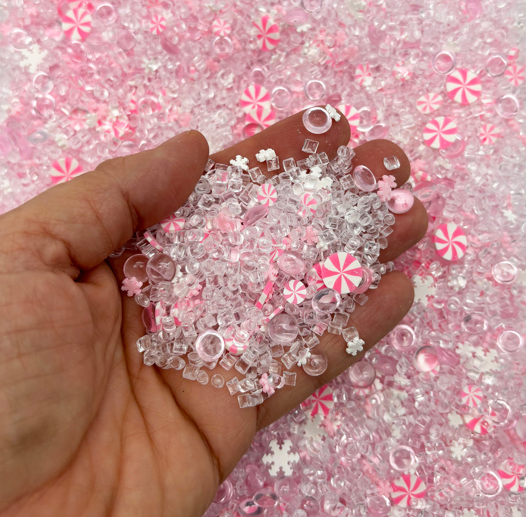 a hand holding a bunch of pink and white beads