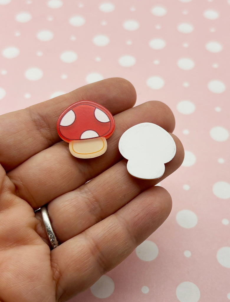 a person is holding a mushroom shaped brooch