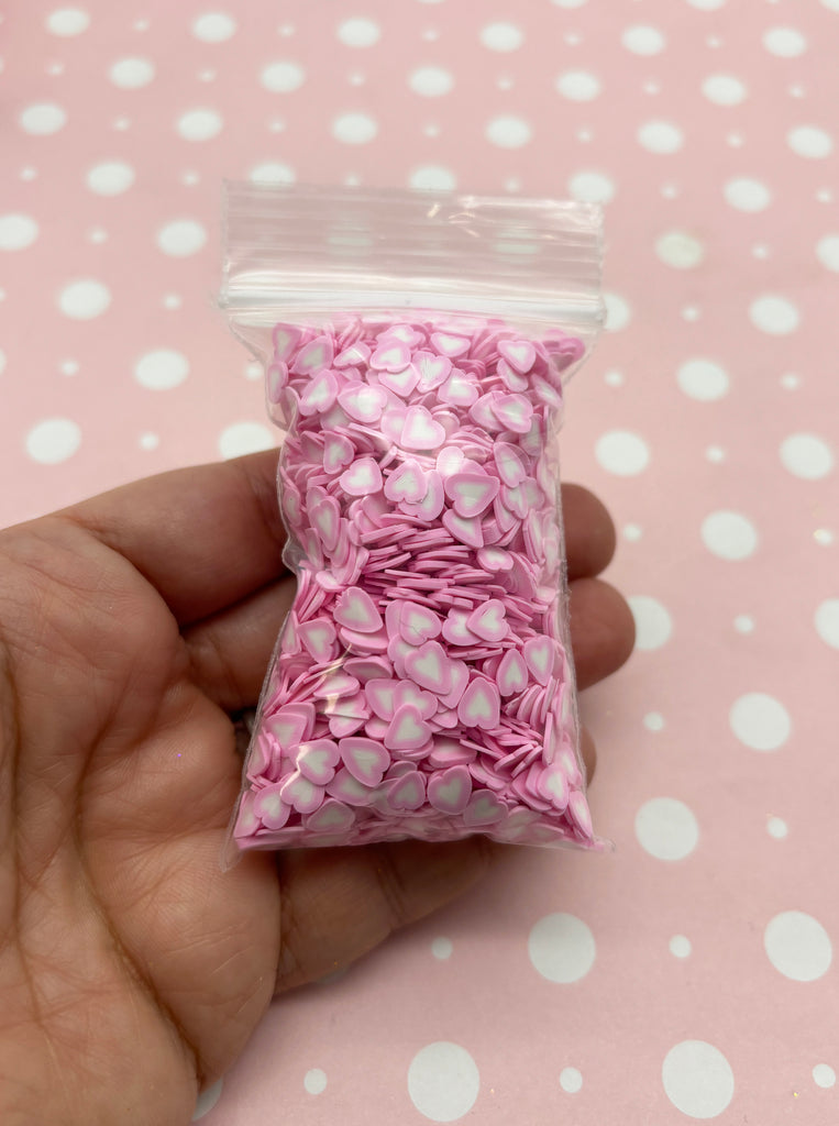 a hand holding a bag of pink and white flowers