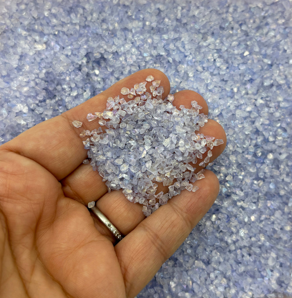 a person holding a handful of small crystals in their hand