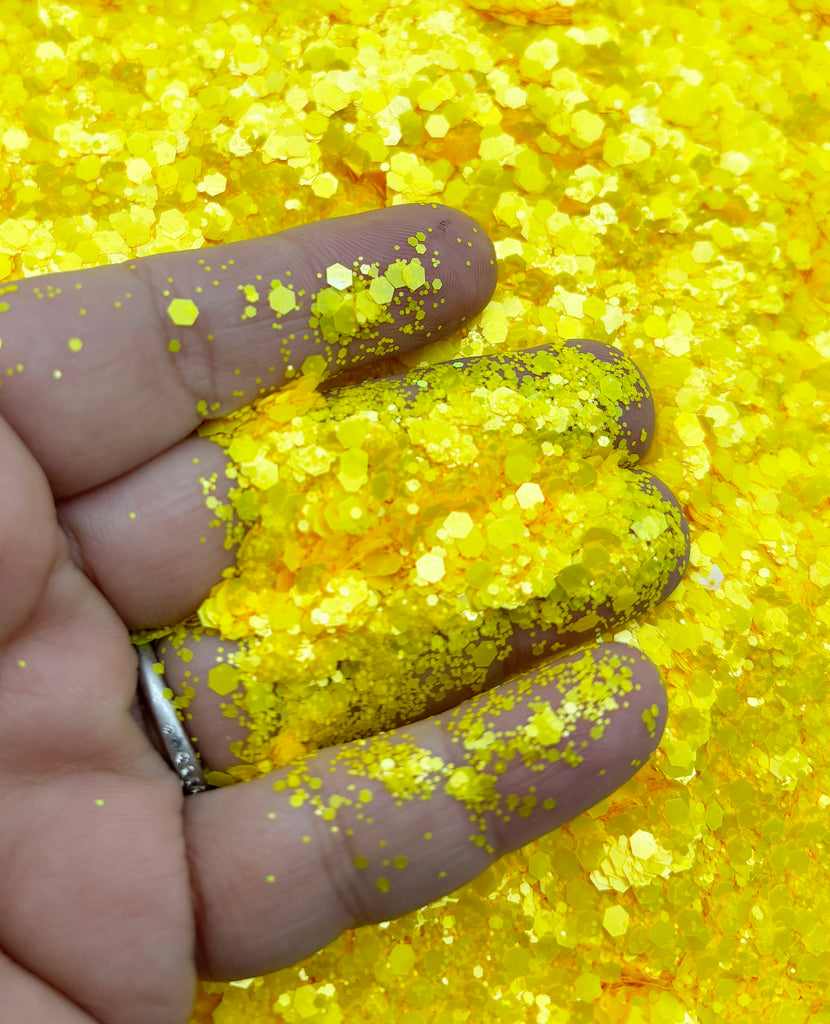 a person's hand with yellow glitter on it