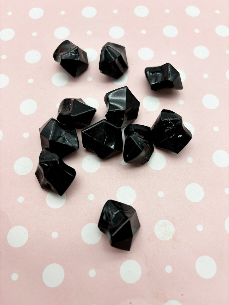 a group of black rocks sitting on top of a table