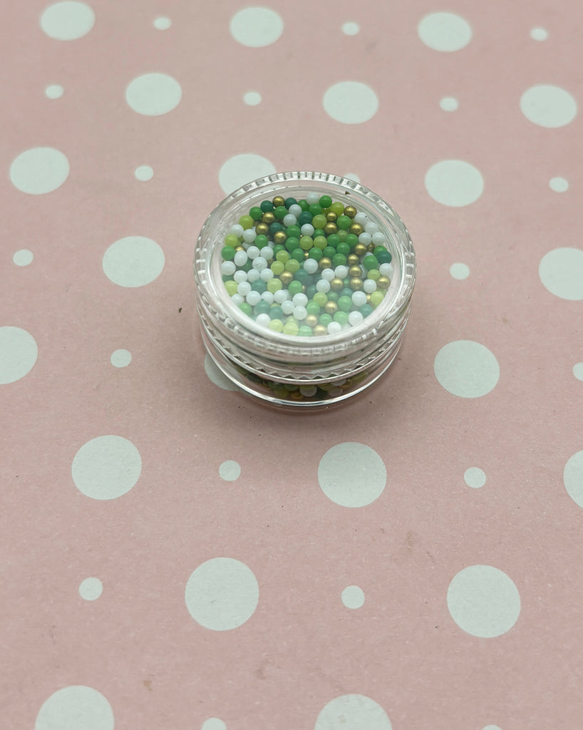 a jar of beads sitting on top of a polka dot tablecloth