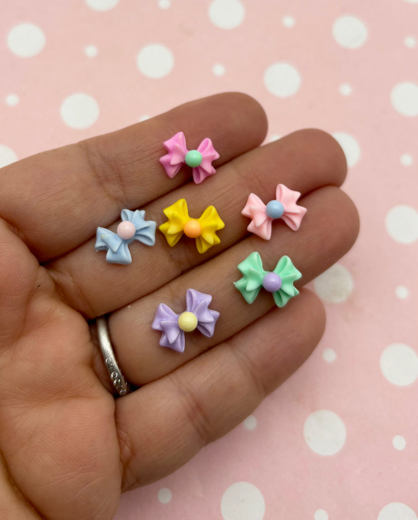 a person holding five small bows in their hand