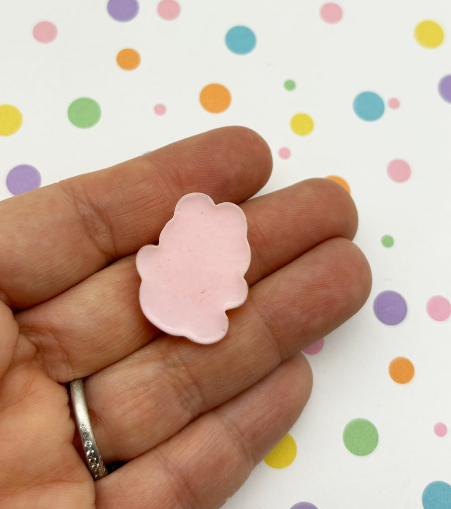 a person holding a small pink flower in their hand