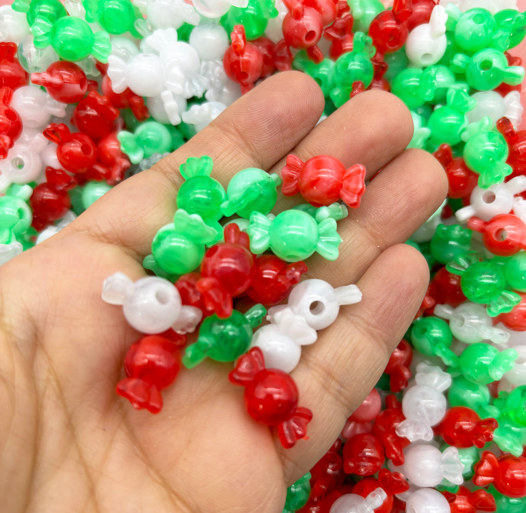 a hand holding a bunch of red, white and green beads