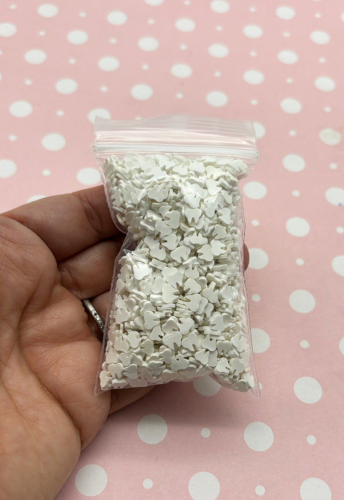 a hand holding a bag of white sprinkles