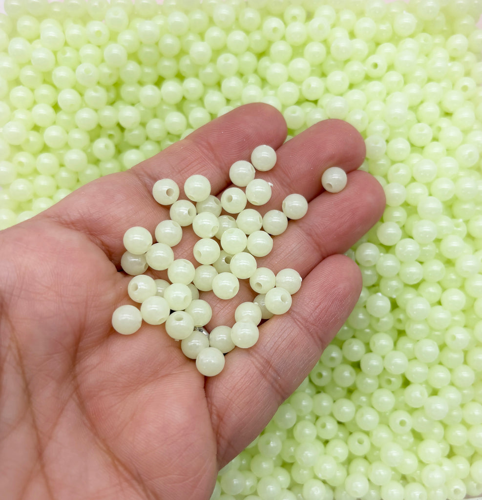 a hand holding a handful of white beads