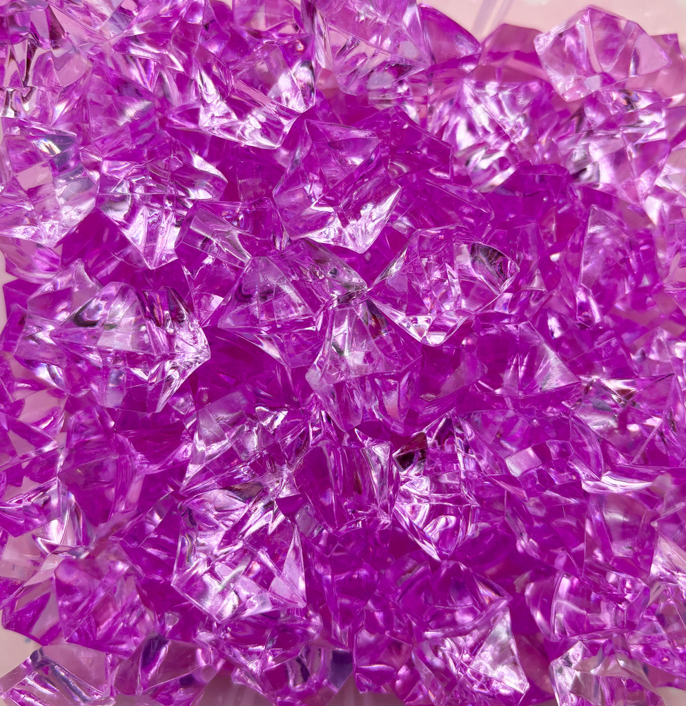 a pile of purple glass shards sitting on top of a table