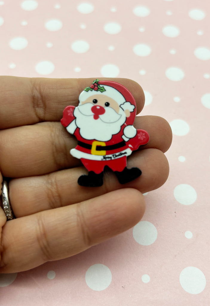 a hand holding a small santa clause ornament