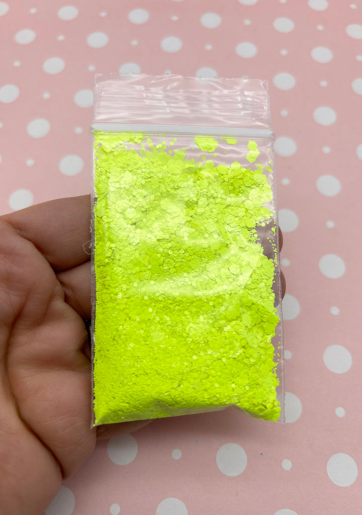 a hand holding a bag of yellow powder