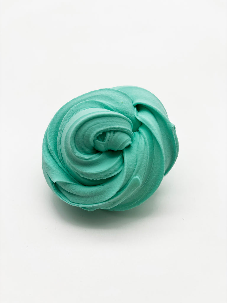 a ball of green icing sitting on top of a white surface