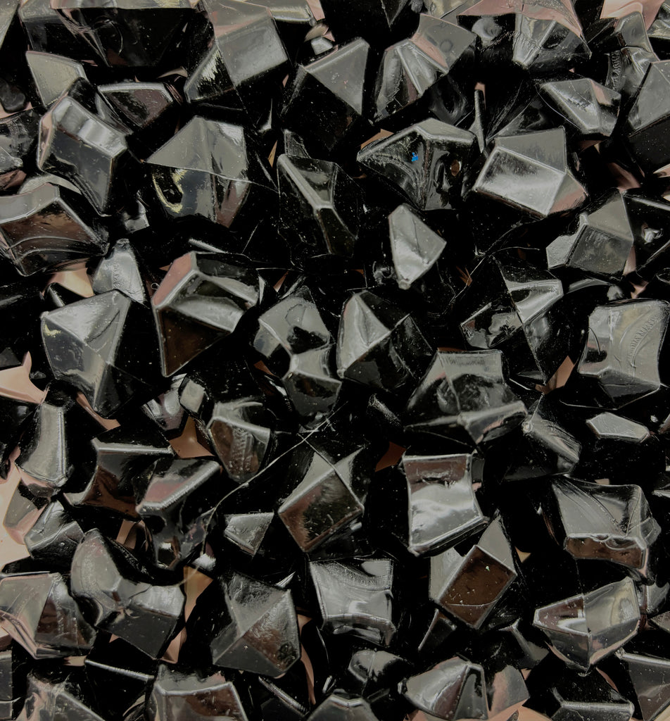 a pile of black rocks sitting on top of a wooden floor