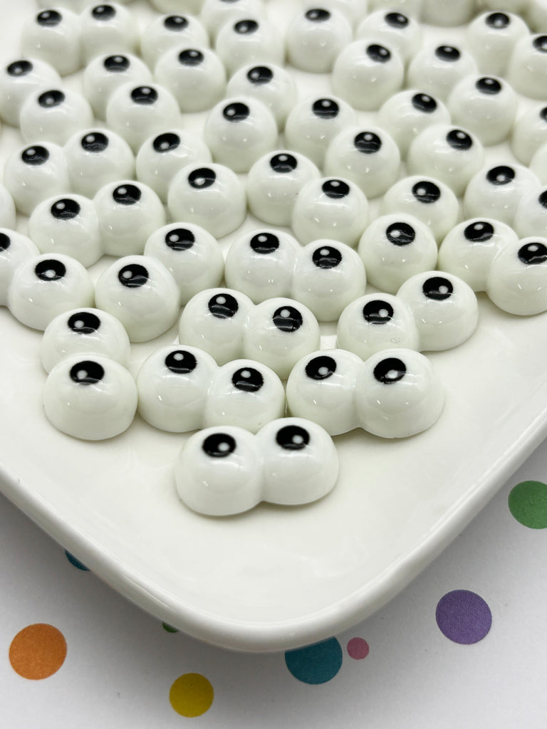 a white plate topped with lots of black and white balls