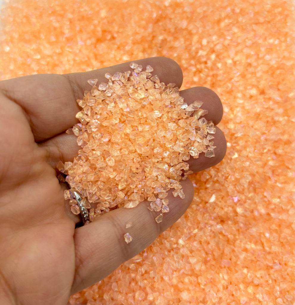 a hand holding a handful of sugar over a pile of sugar