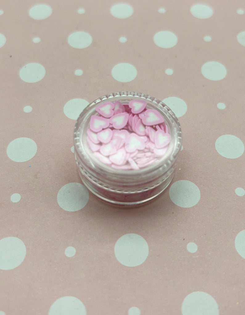 a small jar filled with pink and white candy