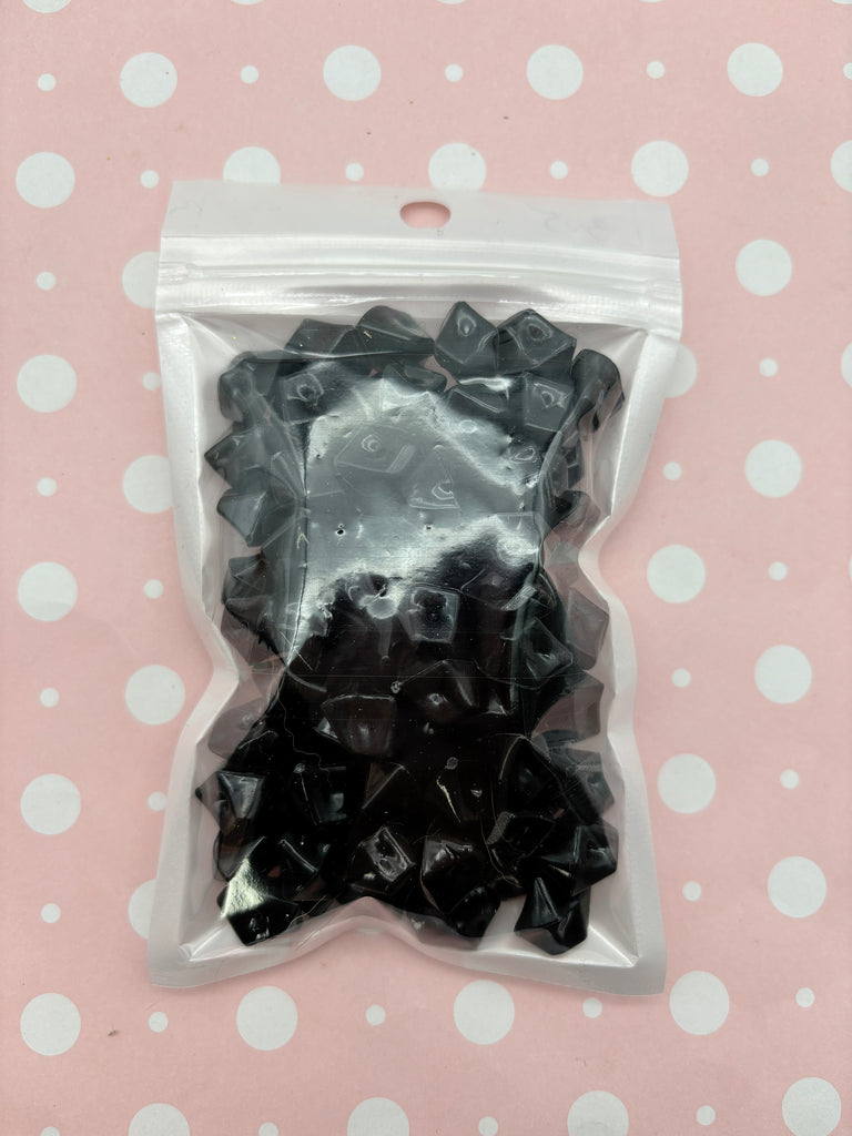 a package of black plastic bows on a polka dot background