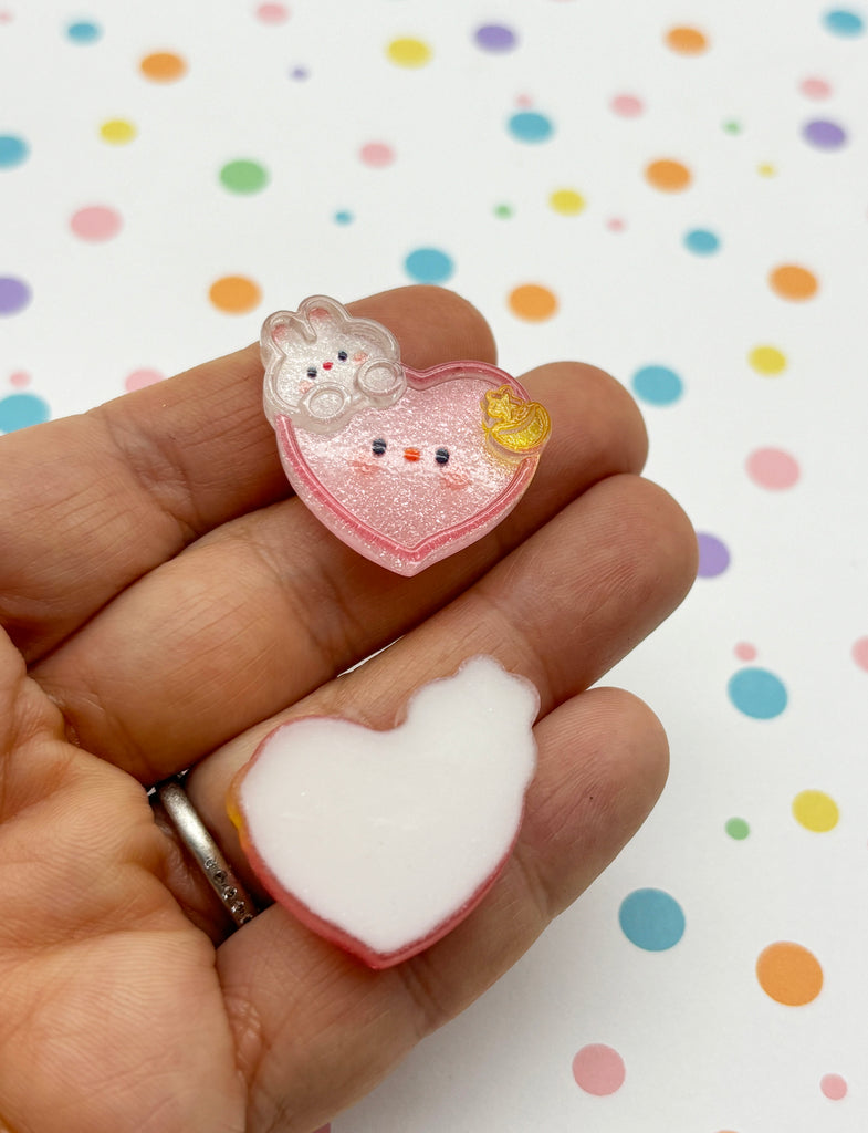 a person holding a small heart shaped object in their hand